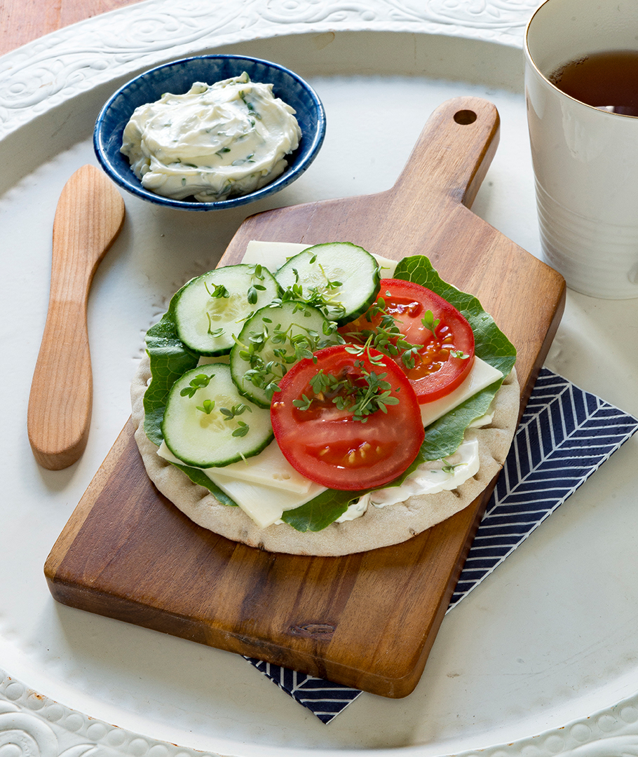 Open sandwich topped with creamed cress, cheese, lettuce, tomato and cucumber