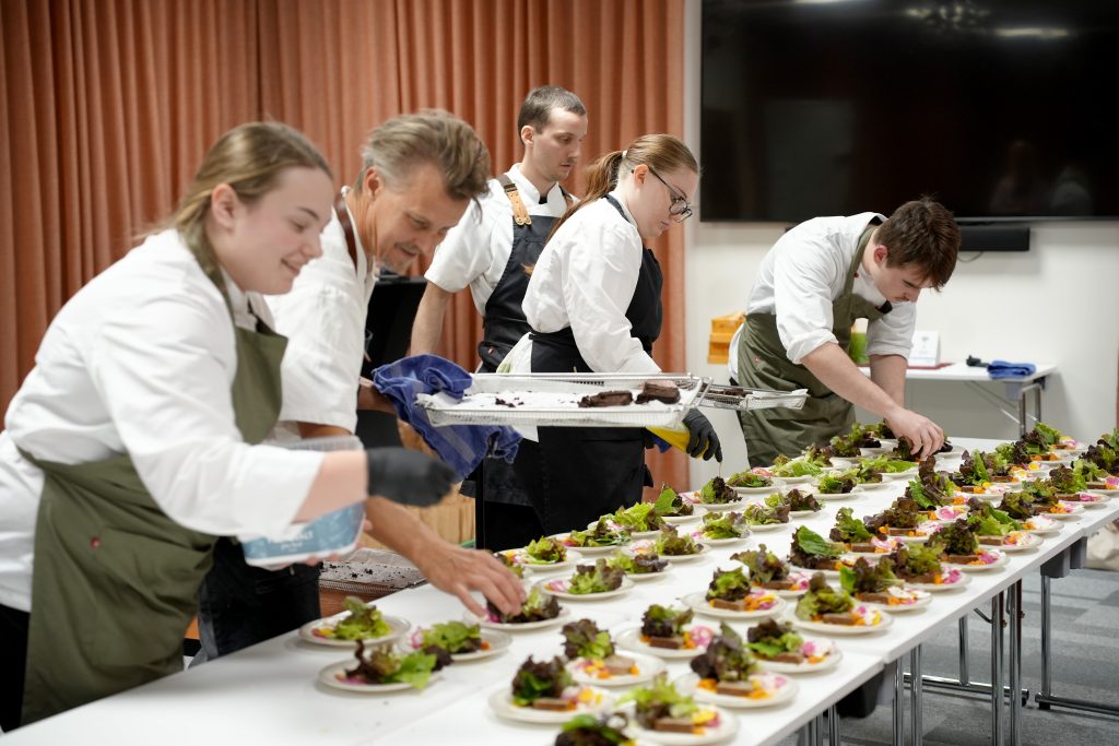 kockar och kockelever lägger upp mat